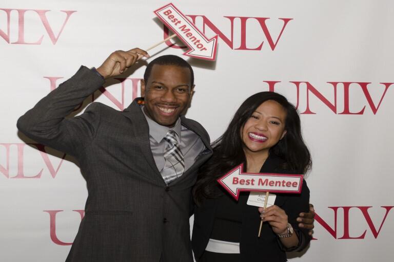 Man and woman holding signs smiling