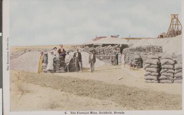An early 1900s color postcard of several people posing by sacks or ore outside of the Florence Mine in Goldfield, Nevada.