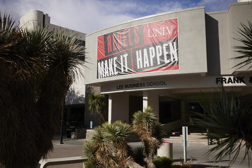 Exterior of the Frank and Estella Beam Hall - home of the Lee Business School. A big banner is hung on the building that reads &quot;Rebels Make It Happen.&quot;
