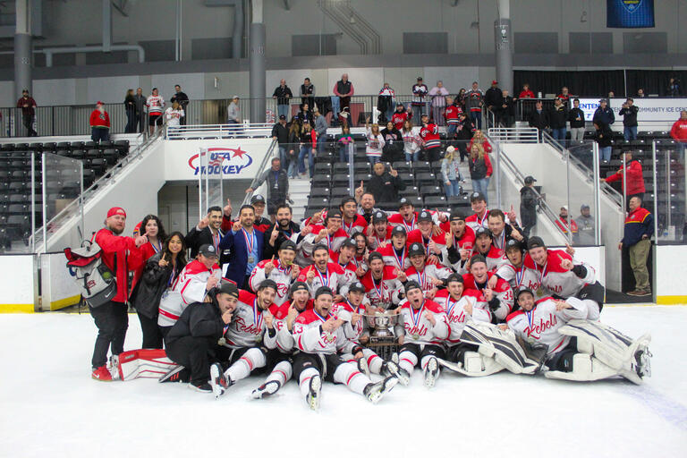 UNLV Hockey team group photo with trophy after championship game